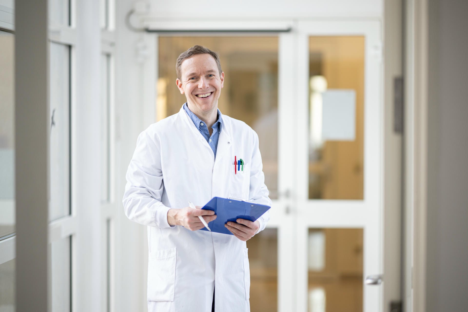 Lächelnder Wissenschaftler mit Klemmbrett